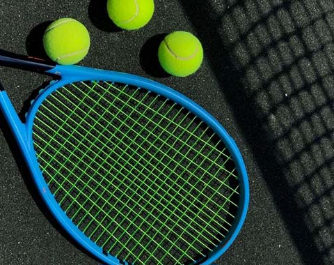 A tennis racket and tennis balls