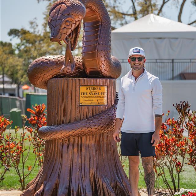 Man getting photo next to snake pit statue